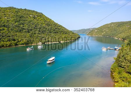 Water Channel In A Mountainous Area. Tourist Boats Sail Along The Channel. Shooting From A Drone.