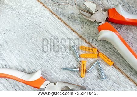Set Of Two Different Types Of Pliers, Side Knives And Fasteners On A Gray Laminate. Image On The The