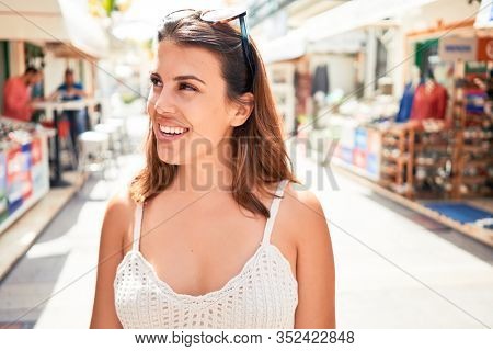 Young beautiful woman at the colorful village of Puerto de Mogan, smiling happy at the street on summer holidays