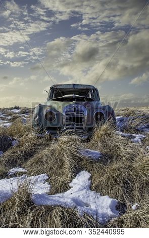 Neidpath, Sk, Canada- Feb. 20, 2020: Abandoned Austin A40 Somerset In The Tall Grass On A Snowy Hill
