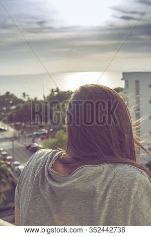 Young Woman Enjoys Sunset, The See Ocean View And Relaxing In The Balcony