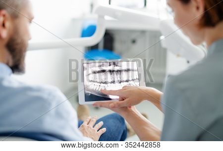 Rear View Of Man And Dentist In Dental Surgery, Annual Check-up.