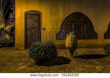 The Exterior Facade Of An Egyptian Villa With Wooden Door And Shutters At Night, El Gouna, Egypt, Ja