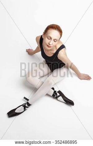 Sport Ideas. Relaxing And Dreaming Caucasian Professional Ballet Dancer In Body Suit  And Pointes Sh