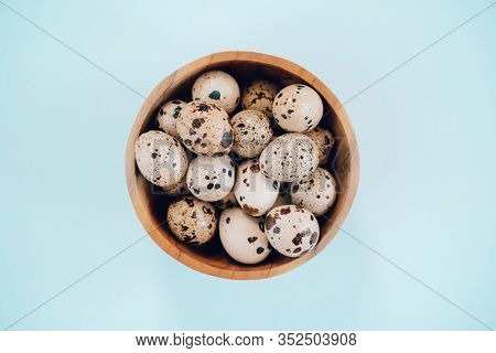 Quail Eggs In Wooden Bowl On A Blue Background. Easter Concept, Flay Lay Photo. Mockup, Space For Te