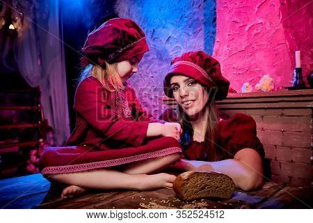Easter And Family. Mother And Daughter In Maroon Or Red Dresses Of The Village Shepherdesses And Sma