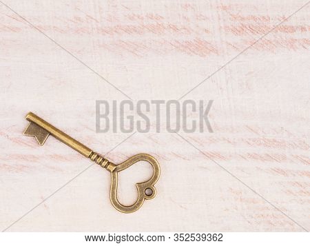 Old Bronze Antique Key On Brown Wooden Background With Copy Space