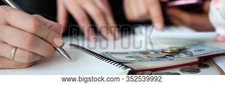 Close-up Of Spouse Writing Down All Purchases And Expenses In Month. Couple Counting Income And Savi