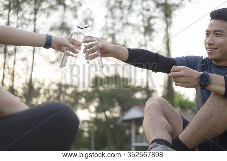 Young Couple Sporter Drinking Water After Workout.