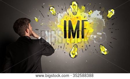 businessman drawing colorful light bulb with IMF abbreviation, new technology idea concept
