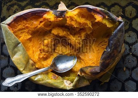 Baked Half Of Pumpkin With Spoon In It On The Baking Tray