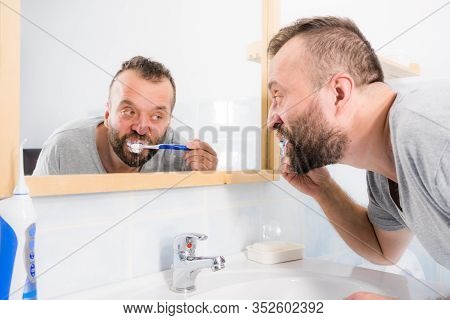 Funnny Guy Taking Care Of His Oral Hygiene, Brushing Teeth During Morning Bathroom Routine.