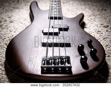 Bass Electric Guitar With Four Strings Closeup. Popular Rock Musical Instrument. Close View Of Brown