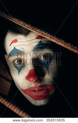 Close-up Portrait Of A Joker Man. Stock Photo Makeup Joker In A Horror Room.