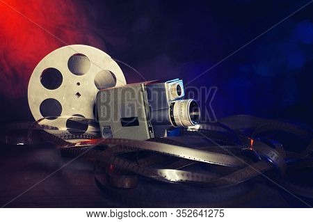 Retro 8 Mm Movie Camera With A Reel Of Film In Smoke. Dark Background