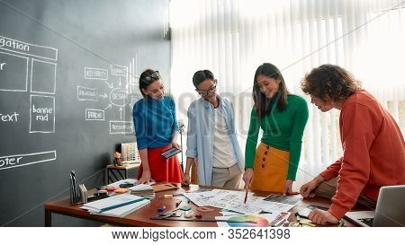 Creative People. Professional Team Of Young Web Designers Working On A New Project Together And Disc