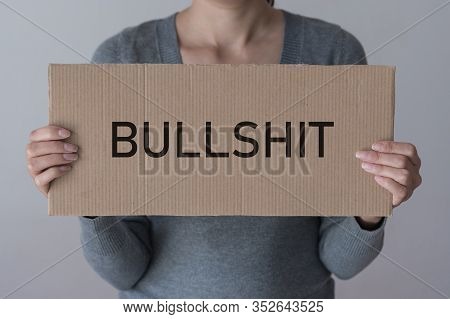 A Woman Holds A Banner With The Inscription Bullshit