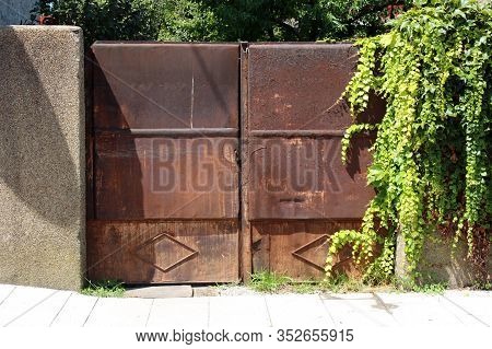 Heavy Massive Old Completely Rusted Metal Closed Front Yard Double Doors Mounted On Concrete Fence W