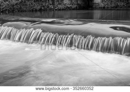 Long Exposure Of A Watefall On The River Lim Walkway At Lyme Regis In Dorset.