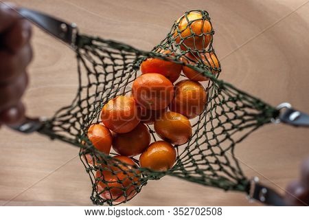 Man Keeps Mandarins In Green Net Bag Zero Waste Concept