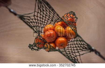 Man Keeps Mandarins In Green Net Bag Zero Waste Concept