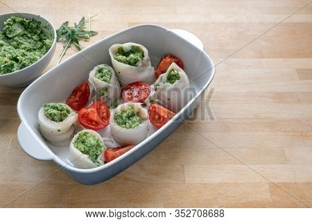 Fish Rolls From Plaice Fillets Filled With Mashed Celery And Arugula Placed With Tomatoes In A Casse
