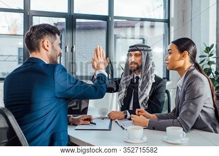 Positive Multicultural Business Partners Giving Highfive On Meeting With Translator In Office
