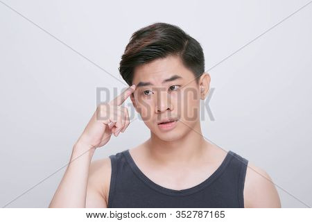 Young Asian Chinese Man Wearing T-shirt Standing Over Isolated White Background Pointing Unhappy To 