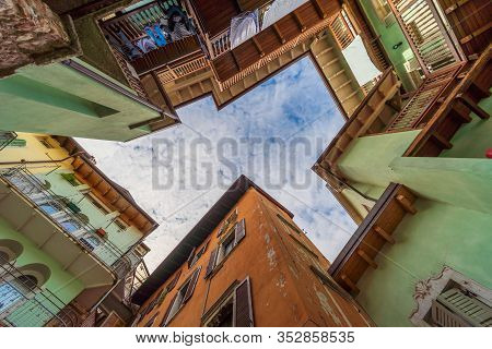Rovereto, Italy Street Blue Sky In Small Historic Medieval Town Village In Trento Looking Up Low Ang