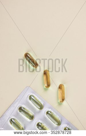 Oil Yellow Capsules On Light Yellow Background, Vitamins And Antioxidant Concept Omega 3, Liver Cod 