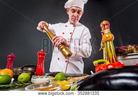 Chef Adding Peppers Mix To Fish Using Big Pepper Mill