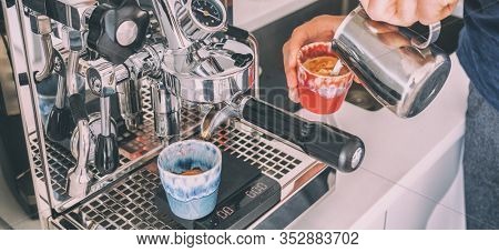 Coffee machine barista man making espresso macchiato pouring steamed froth milk in cup at home banner panoramic.