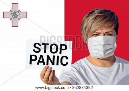 Woman In Face Mask Hold Sheet With Inscription Stop Panic Against Maltese Flag. Concept Of Spread Fa
