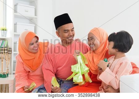 Happy Malay family portrait in traditional clothing during Hari Raya. Malaysian family lifestyle at home.