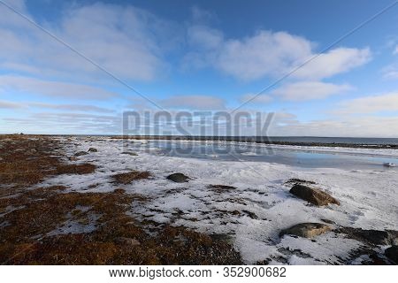 Arctic Landscape With Ice Forming Near A Small Lake And Blue Sky And Clouds In The Background, Near 