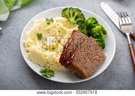 Meatloaf With Glaze Sliced On A Plate With Mashed Potatoes And Broccoli, Ground Beef And Pork Dish