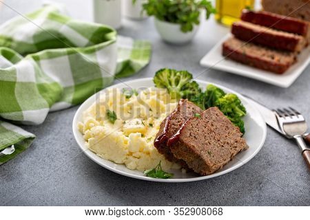 Meatloaf With Glaze Sliced On A Plate With Mashed Potatoes And Broccoli, Ground Beef And Pork Dish