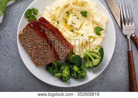 Meatloaf With Glaze Sliced On A Plate With Mashed Potatoes And Broccoli, Ground Beef And Pork Dish