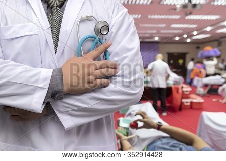 Doctor In Gown Uniform With Stethoscope Standing And Fold His Arms Over The Chest In Blood Donor Roo