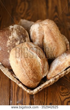 Different Buns Of Fresh Bread On A Brown Vintage Background. Freshly Baked Wheat Bread, Still Life W