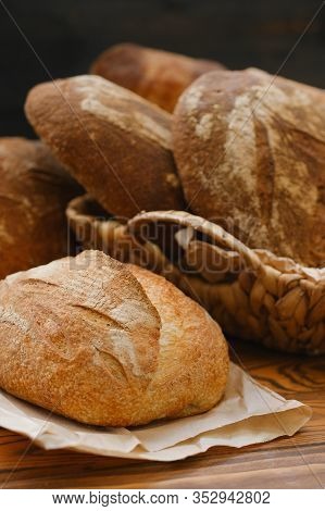 Different Buns Of Fresh Bread On A Brown Vintage Background. Freshly Baked Wheat Bread, Still Life W