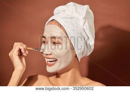 Young Beautiful Woman With Clay Mask On Her Face. Salon Skin Care, Natural Cream Of Algae.