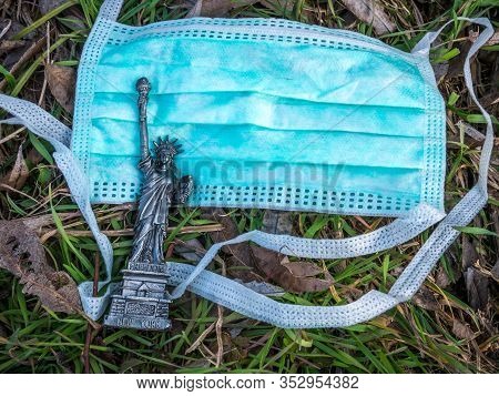 Bucharest/romania - 02.26.2020: Miniature Of Statue Of Liberty Next To A Face Mask Symbolizing The I