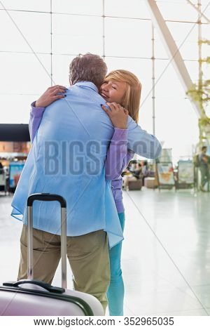 Portrait of mature man reuniting with his daughter in airport