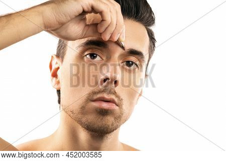 Young Guy Holding Tweezers Near His Eyebrow For Thats Shape Correction