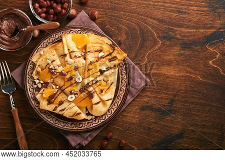 Crepes Suzette With Oranges And Chocolate. Thin Crepes With Chocolate Spread, Hazelnuts And Orange S