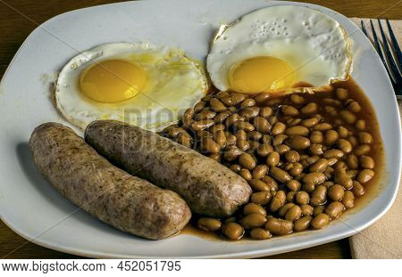 Breakfast Plate  Of Fried Eggs Sausage And Baked Beans