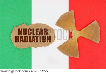 The Concept Of Industry And Radiation. On The Flag Of Italy, The Symbol Of Radioactivity And Torn Ca