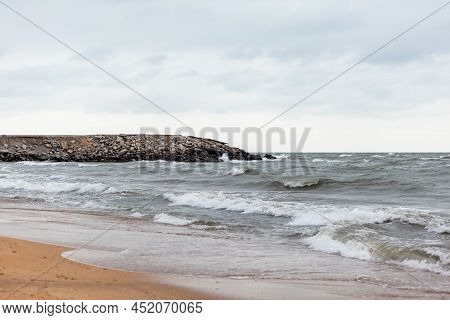 Huge Waves Raging In The Sea And Seagulls In The Spray Of Waves. Storm At Sea. Birds Fly Over The Wa