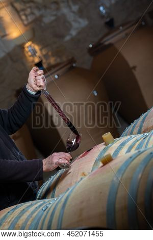 France, Gironde, Saint-emilion, Sampling A Glass Of Wine In A Barrel With A Pipette For Tasting And 